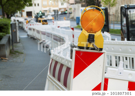 Orange construction Street barrier light on barricade. Road construction on the streets of European cities. Germany. Mainz. Orange construction Street barrier light on barricade. Road construction on the streets of European cities. Germany. Mainz. 101807301