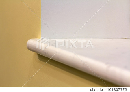 New white marble windowsill install on building yellow plastered wall. Construction, reconstruction and renovation. New white marble windowsill install on building yellow plastered wall. Construction, reconstruction and renovation. 101807376