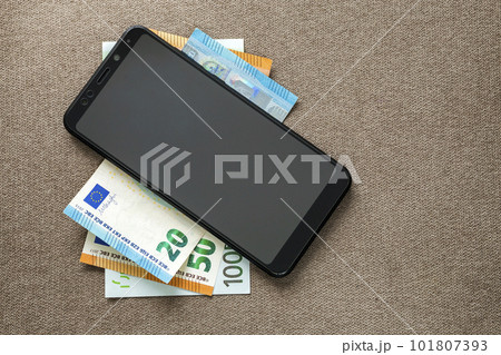 New black modern digital cellphone on money euro banknotes on copy space texture background. Modern technology, communication and online trade using gadget concept. New black modern digital cellphone on money euro banknotes on copy space texture background. Modern technology, communication and online trade using gadget concept. 101807393