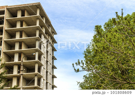 Modern building under construction against blue sky. Construction work site Modern building under construction against blue sky. Construction work site 101808609