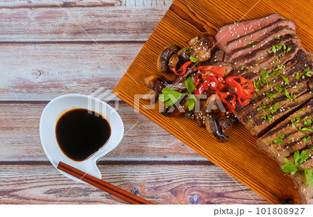 Steak with medium rare level of tenderness grilled on with sliced and mushrooms 101808927