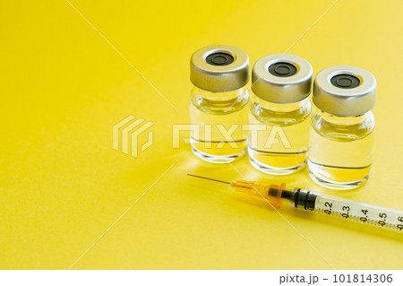 黄色い背景に注射器とバイアル　ビタミン注射のイメージ写真 101814306