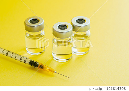 黄色い背景に注射器とバイアル　ビタミン注射のイメージ写真 101814308