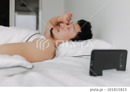 Man just wake up and yawn after an overnight video call with his girlfriend. 101815823