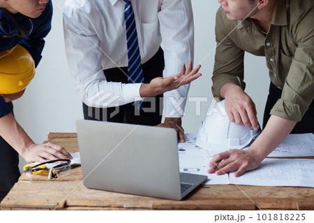 Architect and Engineer working with blueprints for architectural plan, engineer sketching a construction project, green energy concept 101818225