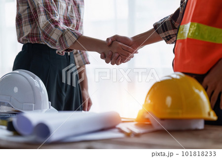 Architect and Engineer working with blueprints for architectural plan, engineer sketching a construction project, green energy concept Architect and Engineer working with blueprints for architectural plan, engineer sketching a construction project, green energy concept 101818233