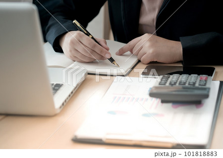 Businesswoman analyzing investment charts and pressing calculator buttons over documents. Accounting Concept. Businesswoman analyzing investment charts and pressing calculator buttons over documents. Accounting Concept. 101818883