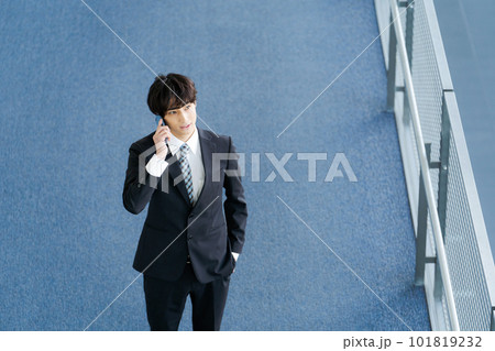 スマホを持つ若いサラリーマンの写真 101819232