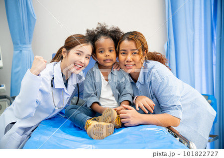 Beautiful doctor woman stay together and close with little girl sit on hospital bed with her mother 101822727