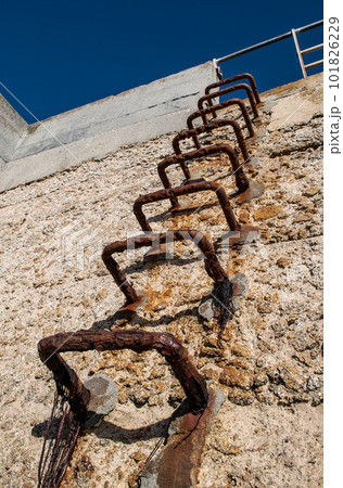 Rusty Iron Ladder On Concrete Harbor Wall In Guilvinec, France Rusty Iron Ladder On Concrete Harbor Wall In Guilvinec, France 101826229