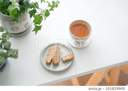 白テーブルに置かれた食べかけのビスコッティと紅茶 101829900