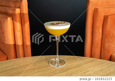 Summer cocktail garnished with passion fruit. rich yellow cold beverage on bar terrace. 101832225