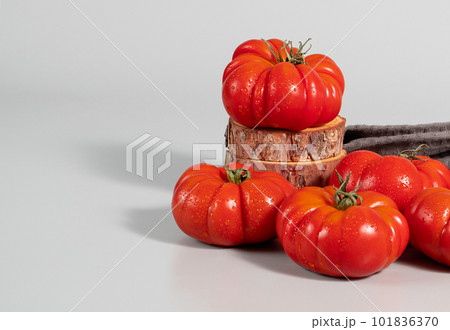 A group of Costoluto big tomatoes on a grey background, textile, space for text A group of Costoluto big tomatoes on a grey background, textile, space for text 101836370