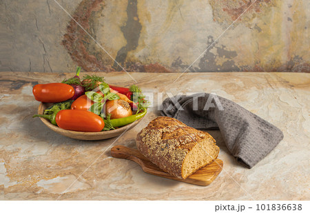Traditional wooden plate with fresh seasonal vegetables: green pepper, tomato, onion, carrot, cucumber, basil, dill; bread, textile on brown vintage background, top view, stock photo Traditional wooden plate with fresh seasonal vegetables: green pepper, tomato, onion, carrot, cucumber, basil, dill; bread, textile on brown vintage background, top view, stock photo 101836638