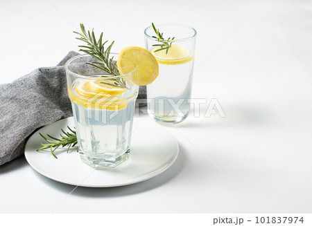 Glass with fresh lemon water or homemade lemonade and rosemary on white background, stock photo Glass with fresh lemon water or homemade lemonade and rosemary on white background, stock photo 101837974