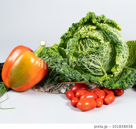 Fresh savoy cabbage, paprika, cucumber, green onion, tomatoes on gray background. Top view detox concept, vegan, food cooking ingredients Fresh savoy cabbage, paprika, cucumber, green onion, tomatoes on gray background. Top view detox concept, vegan, food cooking ingredients 101838038