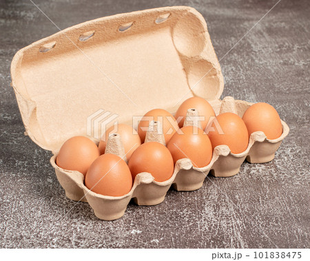 Fresh organic chicken eggs in open carton pack or egg container on brown background, set, stock photo	 101838475