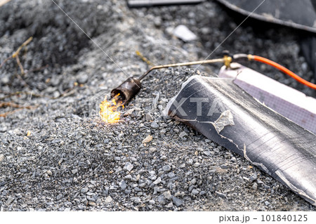flame of fire from a gas burner to heat asphalt belts for building insulation 101840125