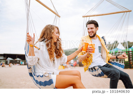 Young and cheerful couple at a music festival. People drinking beer and having fun. Youth, party. 101840630