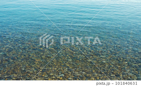 A calm transporent water surface with pebbles stone under water surface 101840631