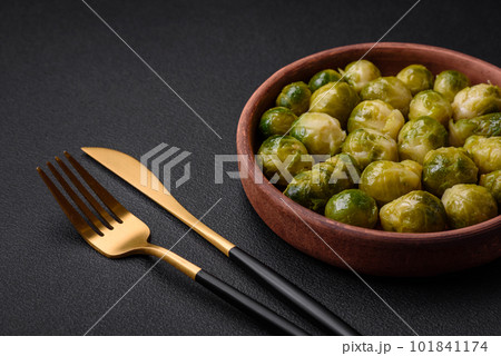 Delicious boiled Brussels sprouts on a ceramic plate on a dark concrete background Delicious boiled Brussels sprouts on a ceramic plate on a dark concrete background 101841174