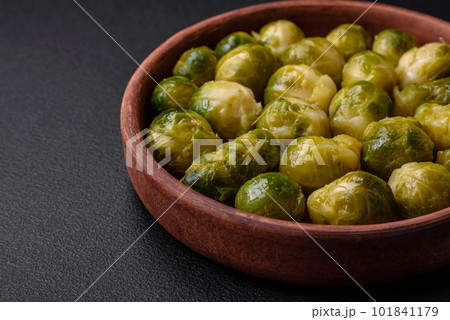 Delicious boiled Brussels sprouts on a ceramic plate on a dark concrete background Delicious boiled Brussels sprouts on a ceramic plate on a dark concrete background 101841179