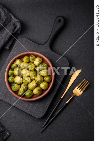 Delicious boiled Brussels sprouts on a ceramic plate on a dark concrete background 101841185