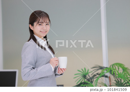 コーヒーカップを持ちオフィスを歩くビジネスウーマン1 101841509