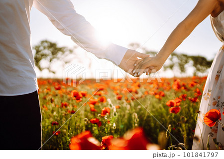 Holding hands of happy young couple having fun in poppy field. Love. Together Holding hands of happy young couple having fun in poppy field. Love. Together 101841797