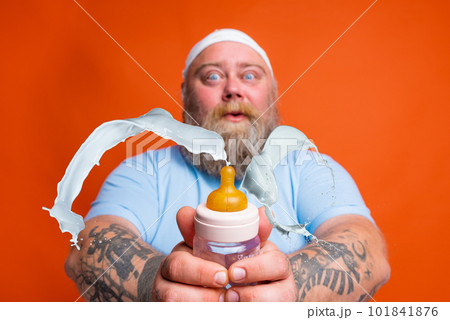 Fat man acts like a child a baby bottle in hand Fat man acts like a child a baby bottle in hand 101841876