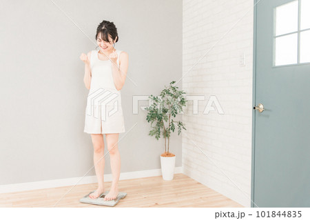 体重計に乗るスリムなアジア人女性(ダイエット・痩身イメージ) 101844835