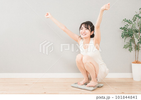 体重計に乗るスリムなアジア人女性(ダイエット・痩身イメージ) 101844841