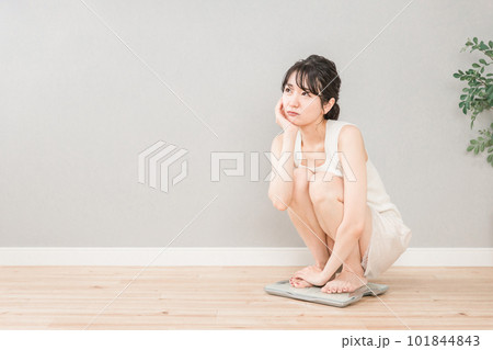 体重計に乗るスリムなアジア人女性(ダイエット・痩身イメージ) 101844843