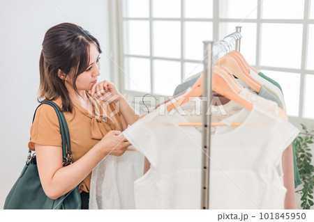 家・洋服屋・アパレルショップで洋服を選ぶ女性（ファッション・ショッピング） 101845950