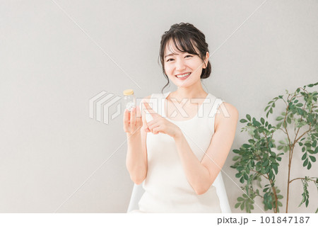 薬・サプリメントの瓶を持つ笑顔のアジア人女性 薬・サプリメントの瓶を持つ笑顔のアジア人女性 101847187