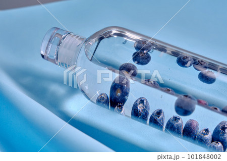 A glass bottle of pure water with blueberries. 101848002