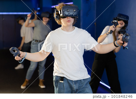 Friends using virtual reality headset and controlling joysticks 101848246