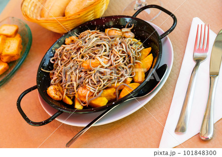 Spainsh dish seafood fried baby eels and prawns with potatoes 101848300