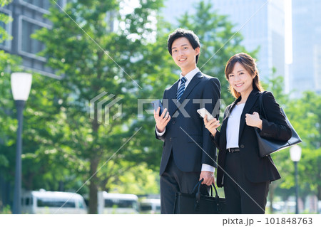 オフィス街でスマホを使う男女のビジネスマン 101848763