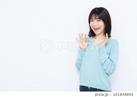 白い背景の前で笑顔でビックリしている30代の女性 101848892