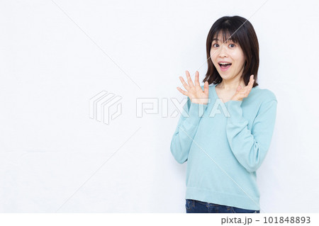 白い背景の前で笑顔でビックリしている30代の女性 101848893