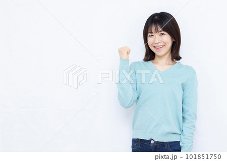 白い背景の前で笑顔でガッツポーズをしている30代の女性 101851750