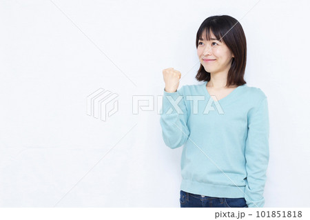 白い背景の前で笑顔でガッツポーズをしている30代の女性 白い背景の前で笑顔でガッツポーズをしている30代の女性 101851818