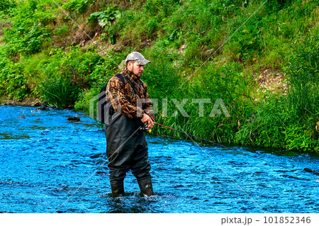 A fisherman catches fish while standing in the water A fisherman catches fish while standing in the water 101852346