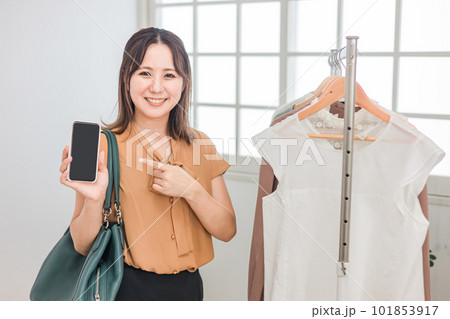 スマホを持ちながら買い物をする女性(ファッション・アパレル・ショッピング) スマホを持ちながら買い物をする女性(ファッション・アパレル・ショッピング) 101853917