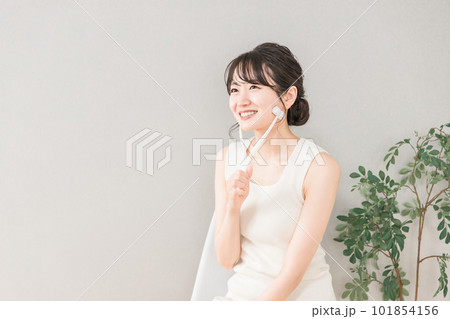 美顔ローラーを使ってマッサージするアジア人女性 101854156