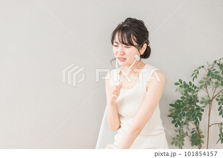 美顔ローラーを使ってマッサージするアジア人女性(痛い) 美顔ローラーを使ってマッサージするアジア人女性(痛い) 101854157
