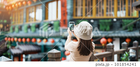 woman traveler visiting in Taiwan, Tourist taking photo and sightseeing in Jiufen Old Street village with Tea House background. landmark and popular attractions near Taipei city. Travel concept 101854241