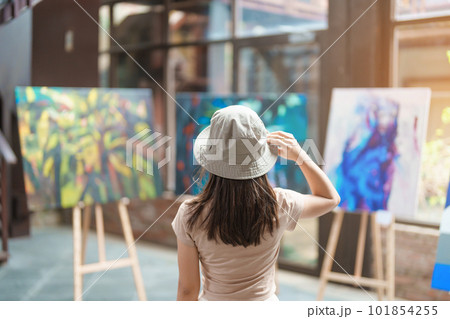 Young female tourist looking gallery exhibition. Art, Painting, photography, Inspiration and museum concept Young female tourist looking gallery exhibition. Art, Painting, photography, Inspiration and museum concept 101854255