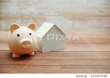 Piggy bank and house model on wooden background,Business investment and real estate concept Piggy bank and house model on wooden background,Business investment and real estate concept 101854586